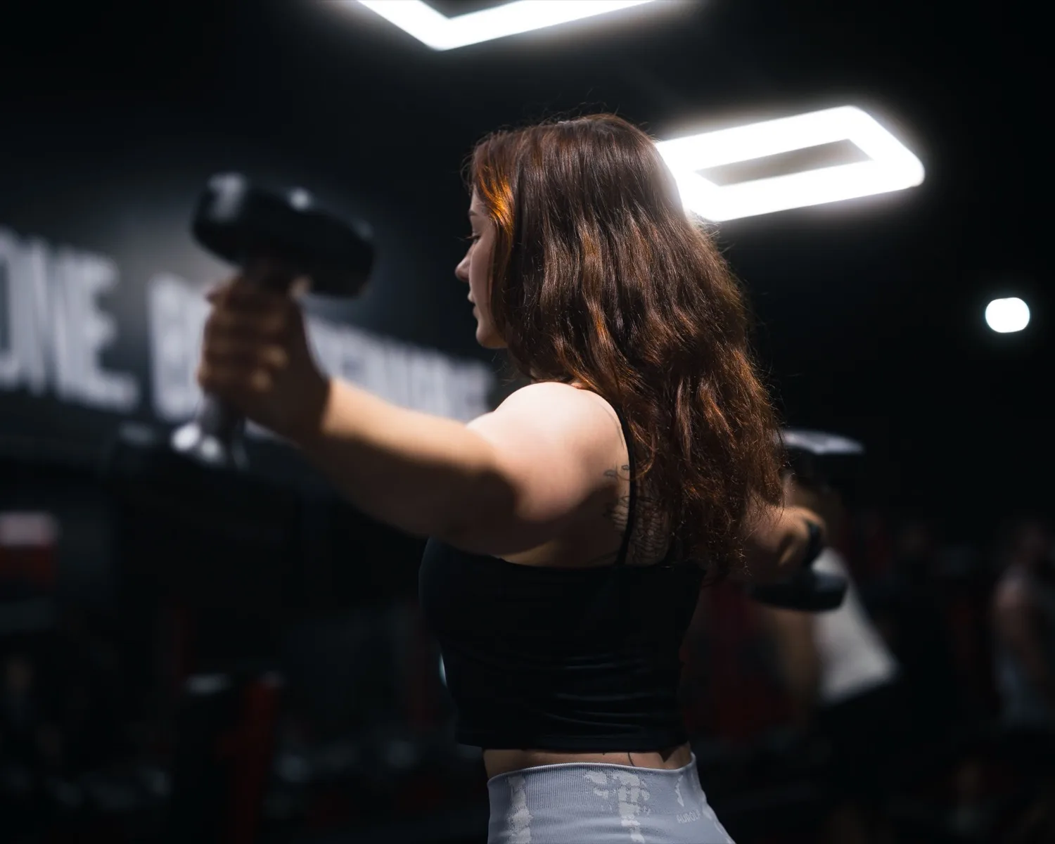 Dumbbell strength training in low, moody light